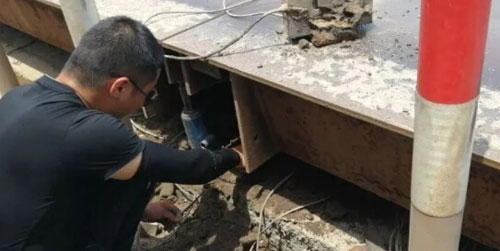 圖為工作人員正在檢查汽車(chē)衡稱(chēng)重傳感器